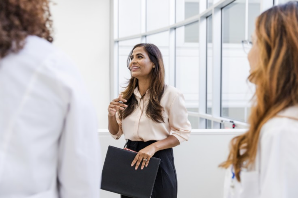 A healthcare administrator speaks with two doctors.